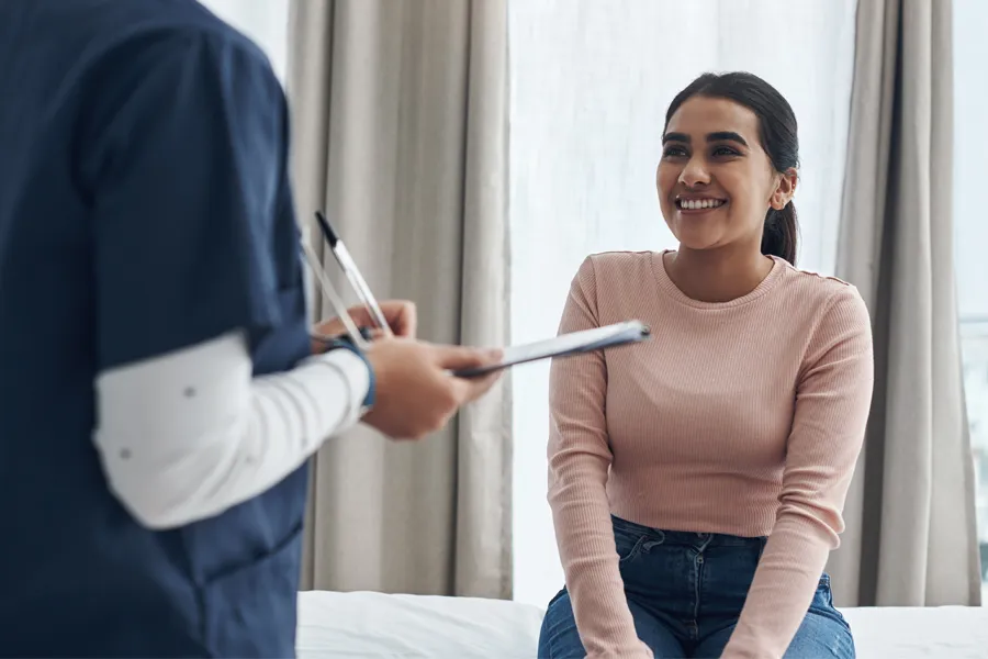 Adult-Physical-Exam-Clinic A woman speaks to a clinician before a physical exam. Get adult physical exams from Nonkulie Dladla, M.D. in Manhattan.