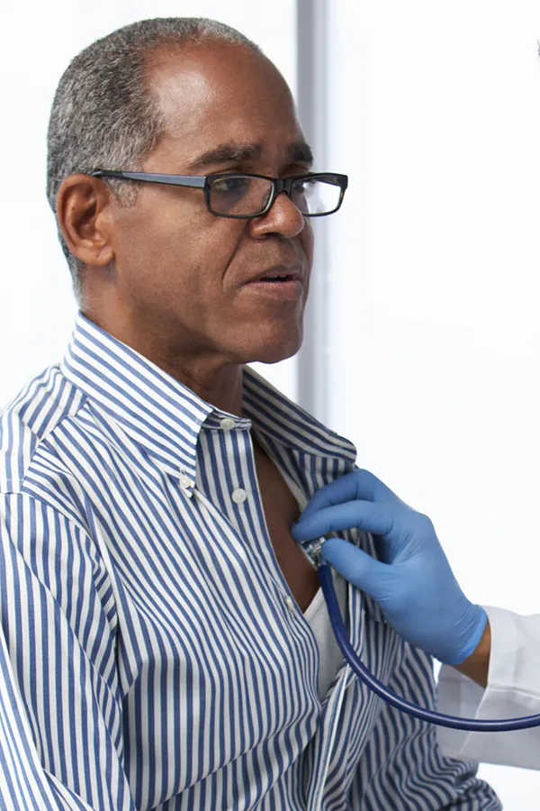 Cardiovasuclar-Care-Treatment A middle-aged Black man gets checked with a stethoscope. Get treatment for cardiovascular health from Nonkulie Dladla, M.D. in Manhattan.