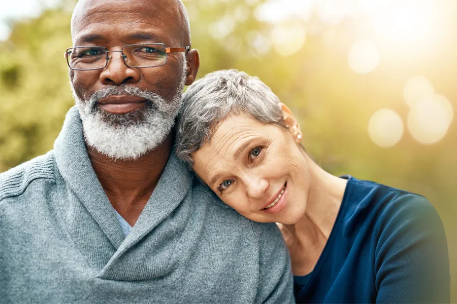 EDTA-IV-Therapy-Clnic A middle-aged couple smile outside. Get EDTA IV Therapy from Nonkulie Dladla, M.D. in Manhattan.