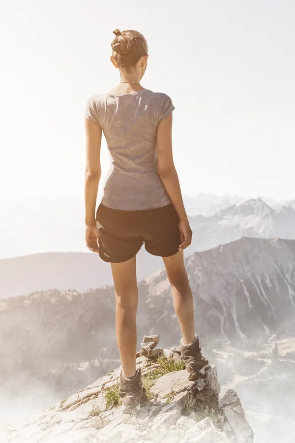EMSculpt-for-Chronic-Pain-Treatment A pain-free woman stands on a mountaintop. Get EMSculpt treatment for Pain relief from Nonkulie Dladla, M.D. in Manhattan.