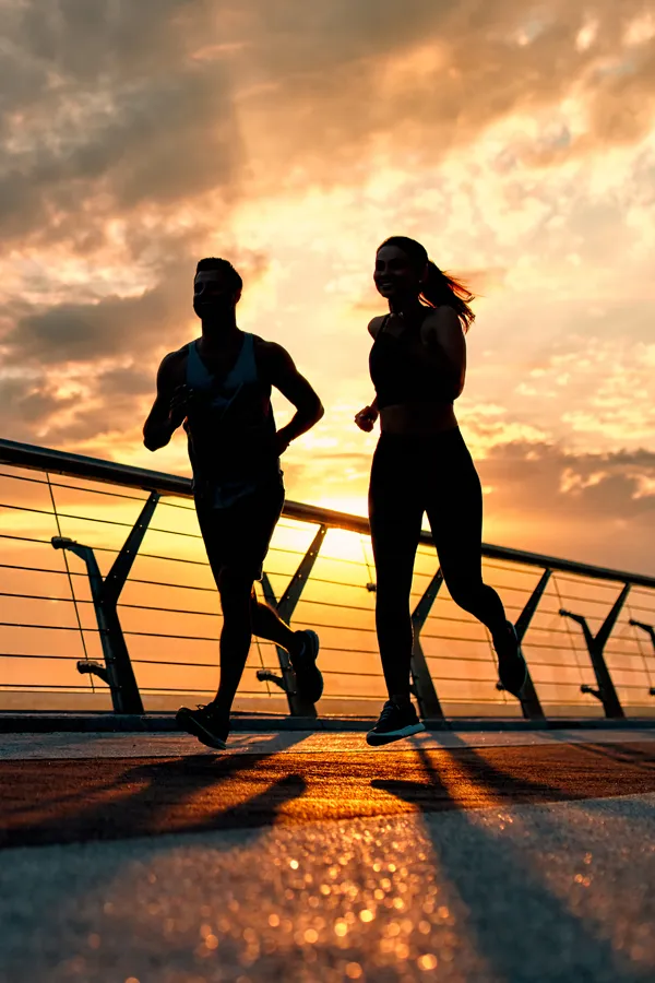Energetic-Assessment-Treatment A couple on a run silhouetted by the sunrise. Get an energetic assessment from Nonkulie Dladla, M.D. in Manhattan.