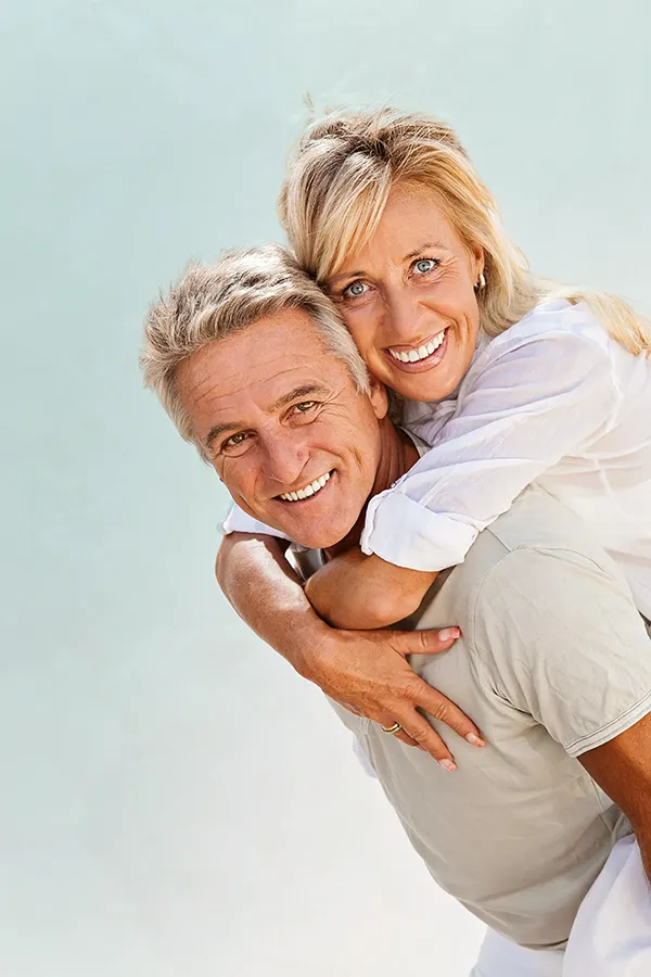 Food-Allergies-Treatment-1 A happy mature couple having fun - the husband is carrying his wife on his back. Get treatment for food allergies from Nonkulie Dladla, M.D. in Manhattan.