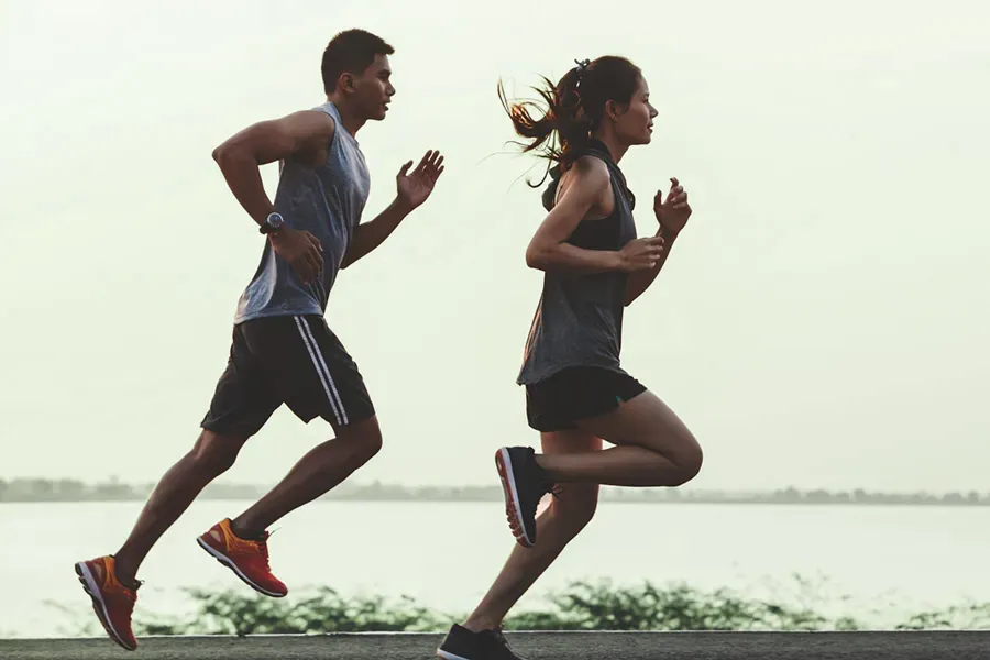 GLP-1-Weight-Loss-Injections-Clinic A couple in profile running along the water. Schedule GLP-1 Weight Loss Injections from Nonkulie Dladla, M.D. in Manhattan.