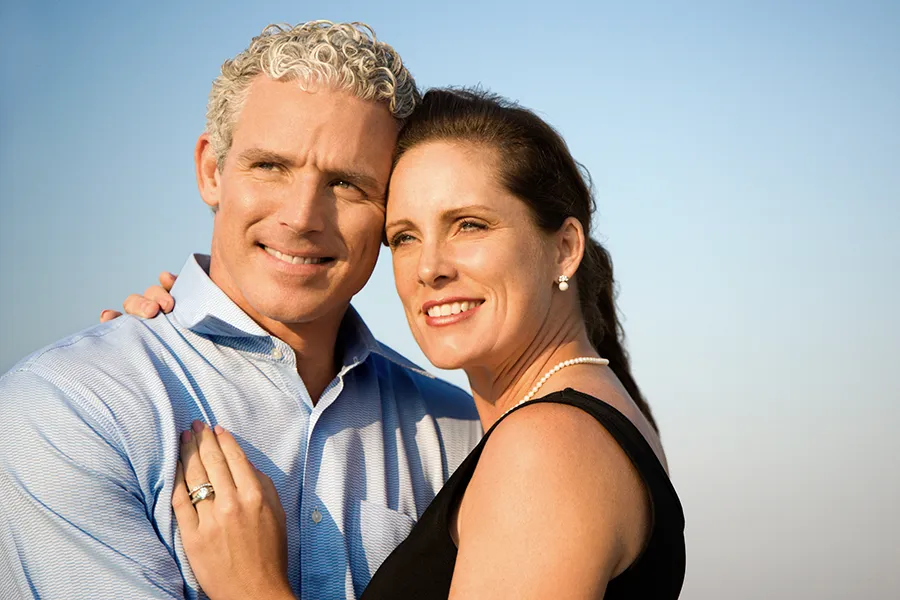 Healthy-Aging-Peptides-Doctor A middle-aged caucasian couple embraces in the sunshine, happy with the healthy aging peptide treatments from Nonkulie Dladla, M.D. in Manhattan