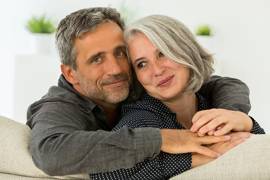 Hormonal-and-Vitality-Peptides-Clinic A middle-aged couple holding each other on the couch. Get Hormonal and Vitality Peptide Treatment from Nonkulie Dladla, M.D. in Manhattan.