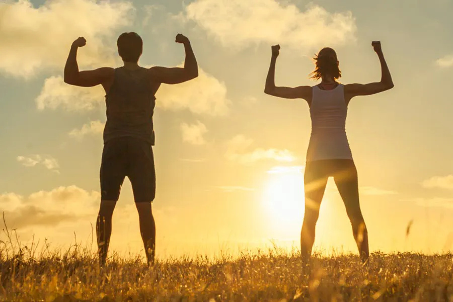 Immune-Optimization-Peptides-Clinic A couple flex their arms outside in the sunrise. Schedule Immune Optimization Peptide Treatment from Nonkulie Dladla, M.D. in Manhattan.