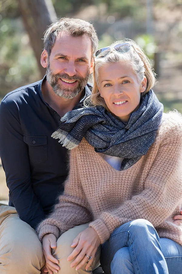 Inflammotory-Bowel-Disease-IBD-Treatment Happy middle-aged couple outdoors wearing cozy fall clothes, smiling calmly. Nonkulie Dladla, M.D. is a compassionate IBD specialist in Manhattan supporting long-term gut health and symptom relief through functional medicine.