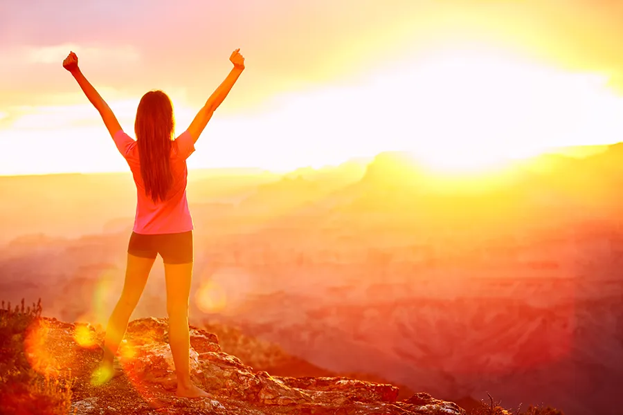 Kailo-Emotional-Medicine-Clinic A woman on a mountaintop at sunrise with outstretched arms . Get Kailo Emotional Medicine treatment from Nonkulie Dladla, M.D. in Manhattan.
