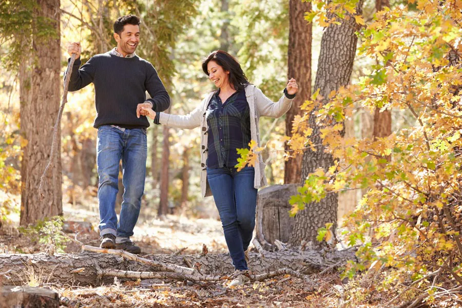 Lyme-Disease-Clinic A couple happily hiking in the forest in fall. Get treatment for Lyme Disease from Nonkulie Dladla, M.D. in Manhattan.