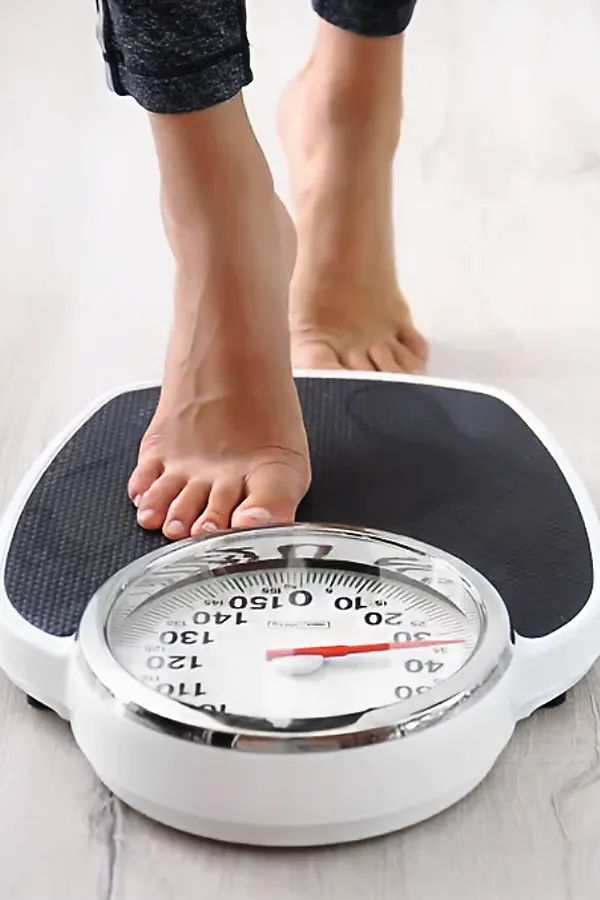 Metabolilc-and-Weight-Optimization-Peptides-Treatment A woman steps onto a scale. Get Metabolilc and Weight Optimization Peptides treatment from Nonkulie Dladla, M.D. in Manhattan.