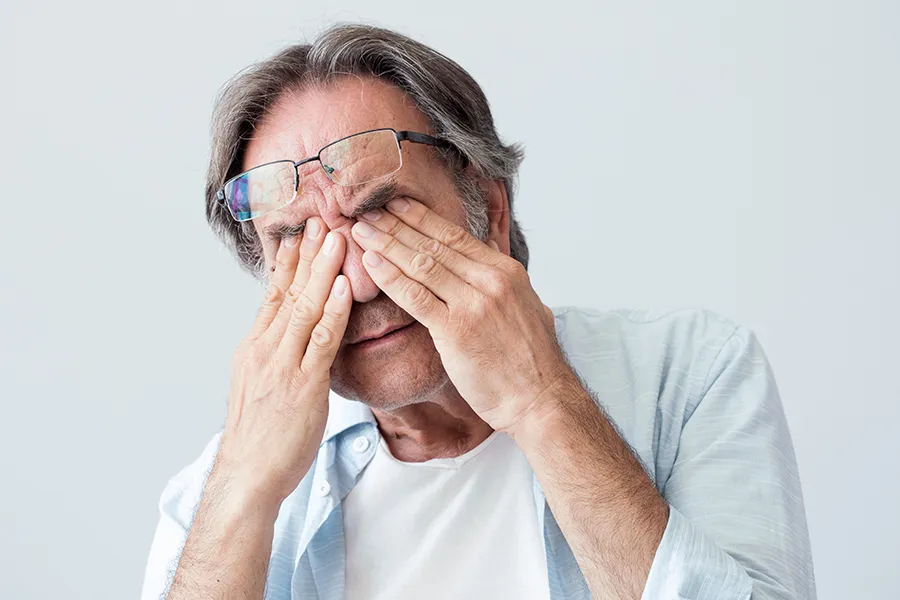 Migraine-Clinic Get migraine relief with Nonkulie Dladla, M.D.'s functional medicine for migraines treatment in Manhattan, represented by an older man rubbing his eyes due to head pain.