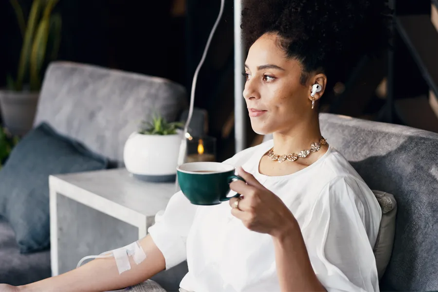 Mineral-IV-Drip-Clinic A woman with a cup of tea gets an IV treatment. Schedule a Mineral IV Drip from Nonkulie Dladla, M.D. in Manhattan.
