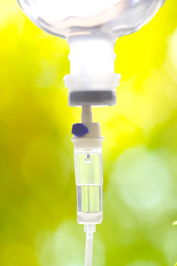 NAD-Therapy-Treatment Close up of an IV drip with a lush, green background. Get NAD Therapy from Nonkulie Dladla, M.D. in Manhattan.
