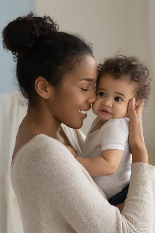 Postpartum-Hormone-Imbalance-Treatment A black woman happily touches her forehead to her infant's head. Get treatment for postpartum hormone imbalance from Nonkulie Dladla, M.D. in Manhattan.