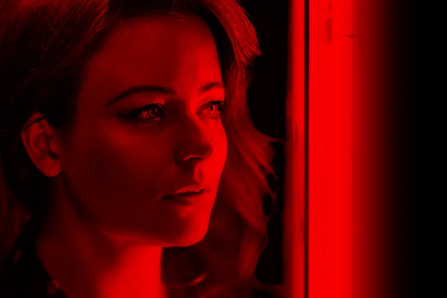 Red-Light-Therapy-for-Hair-Restoration-Clinic A woman with full beautiful hair standing in red light. Get red light therapy for hair restoration from Nonkulie Dladla, M.D. in Manhattan.