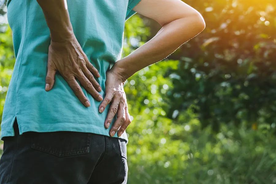 Regenerative-Medicine-for-Back-Pain-Clinic A woman holds her lower back in pain. Schedule Regenerative Medicine for Back Pain from Nonkulie Dladla, M.D. in Manhattan.