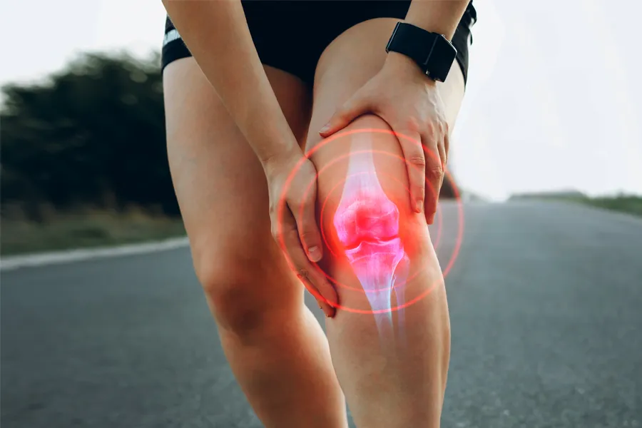 Regenerative-Medicine-for-Inflammation-Clinic A woman stops during a run to grip her knee in pain. Schedule Regenerative Medicine for Inflammation from Nonkulie Dladla, M.D. in Manhattan.