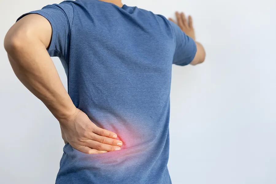 Sciatica-Clinic A man holds his lower back in pain. Schedule sciatica treatment from Nonkulie Dladla, M.D. in Manhattan.