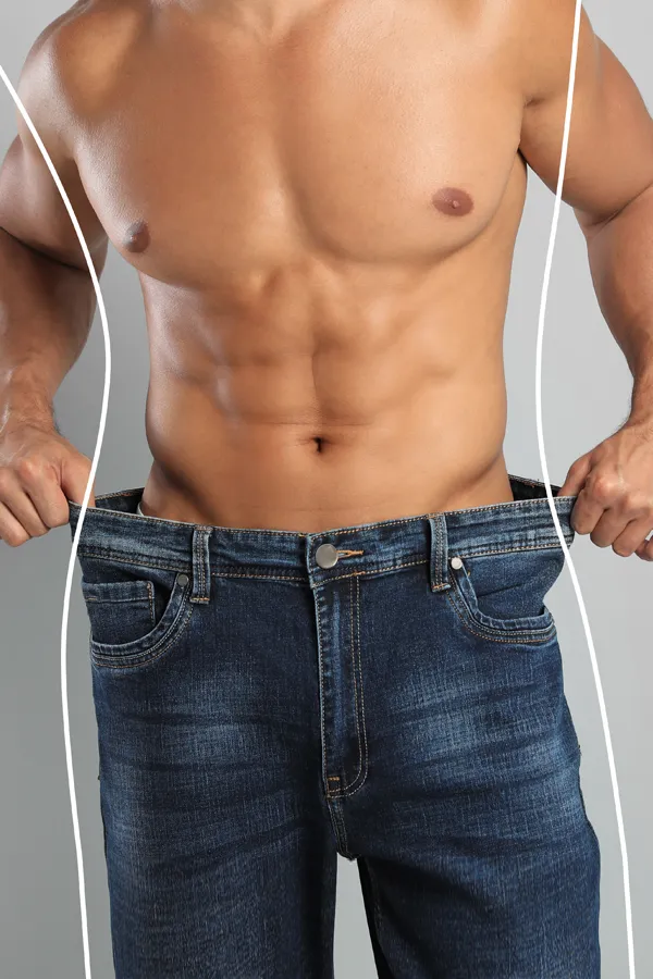 Semaglutide-Weight-Loss-Treatment A strong shirtless man in jeans holds the waistlines of his too-big jeans to show the success of semaglutide weight loss from Nonkulie Dladla, M.D. in Manhattan.