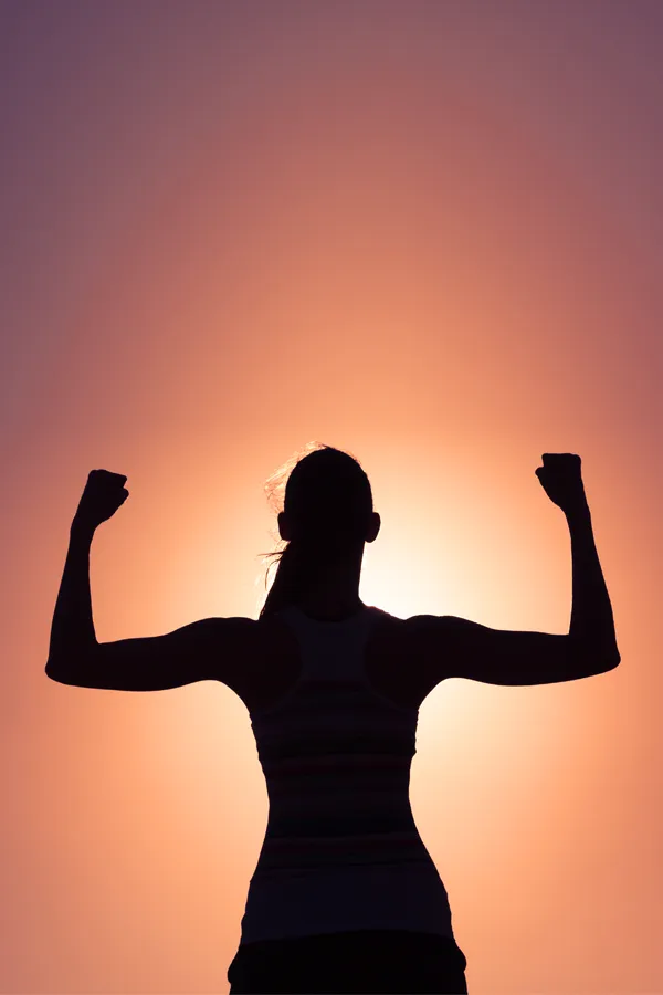 Stem-Cell-IV-Therapy-Treatment A woman silhouetted by the sunset flexes her strong arms. Get Stem Cell IV Therapy from Nonkulie Dladla, M.D. in Manhattan.