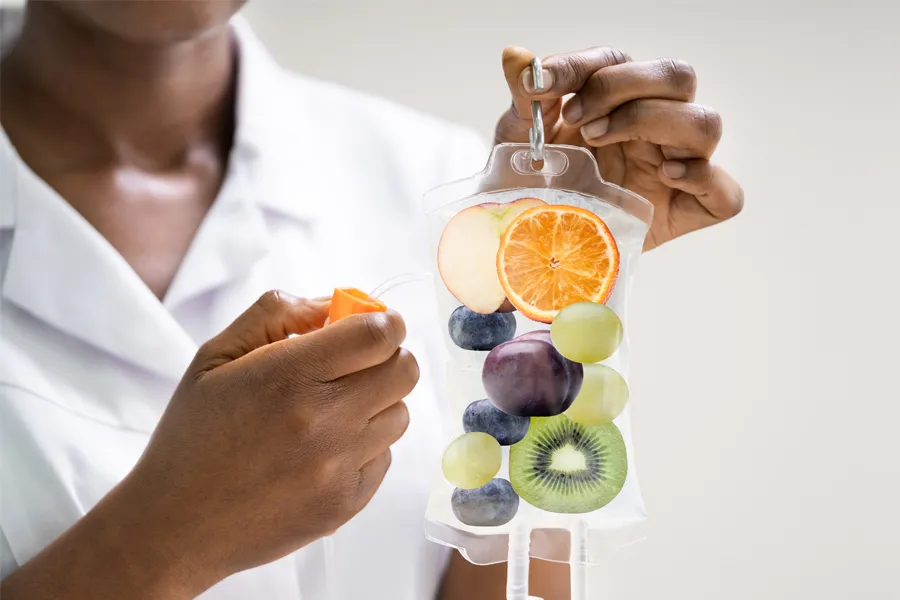 Vitamin-B5-Drip-Clinic A clinician holds an IV bag filled with fruit. Get a Vitamin B5 IV drip treatment from Nonkulie Dladla, M.D. in Manhattan.