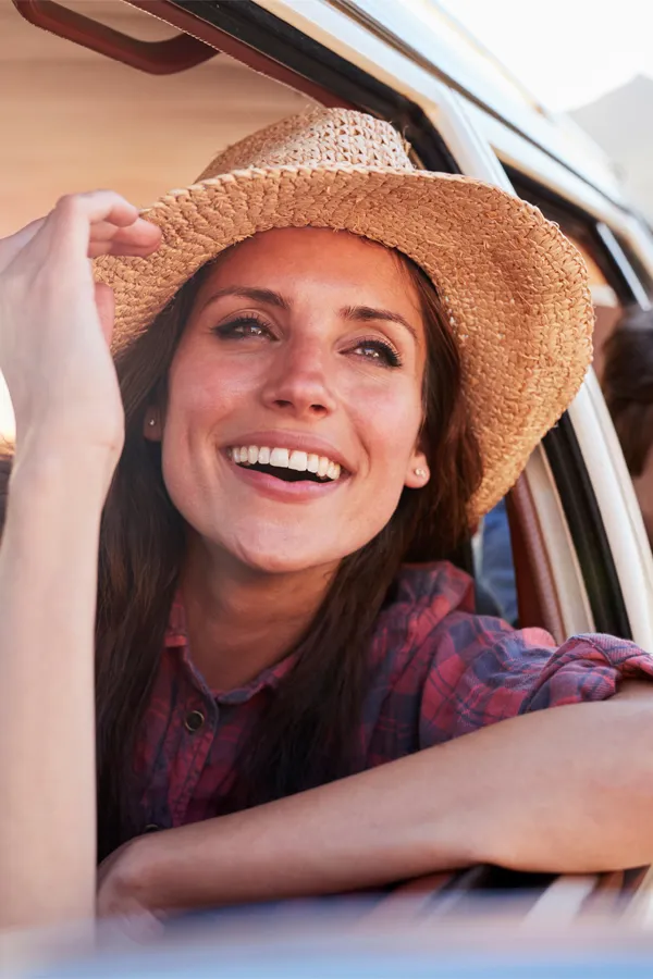 Vitamin-D-Injections-Treatment A woman with a sun hat leans out a car window smiling. Get Vitamin D injections from Nonkulie Dladla, M.D. in Manhattan.