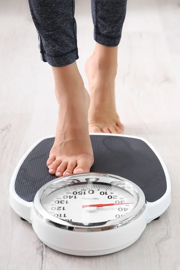 Weight-Loss-Counseling-Treatment A woman stepping onto a scale. Get weight loss counseling from Nonkulie Dladla, M.D. in Manhattan.