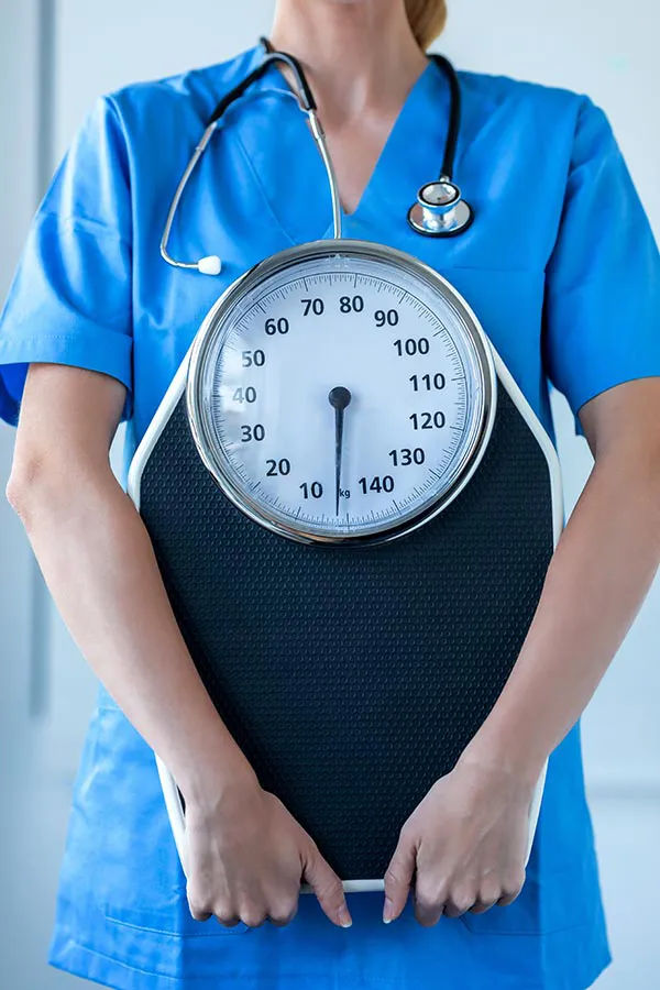 Weight-Management-Program-Treatment A clinician holds a scale. Sign up for the weight management program with Nonkulie Dladla, M.D. in Manhattan.